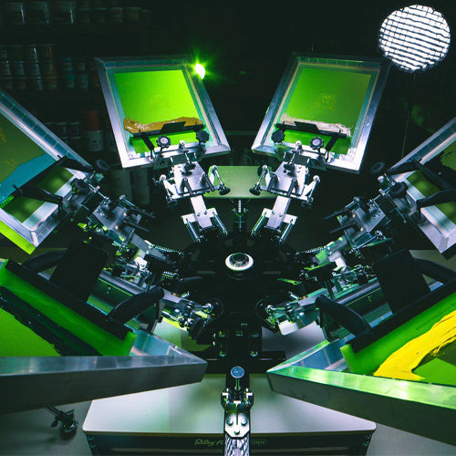 Manual screen printing machine with multiple printing heads on a dark background