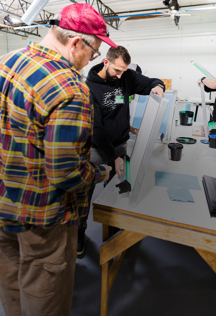 Instructor showing a student how to coat a screen.
