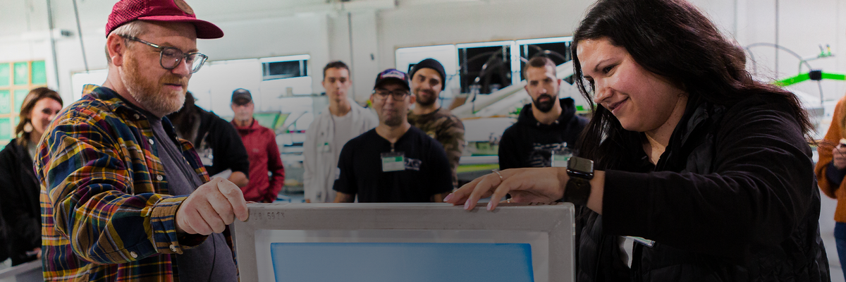 Instructors showing a student how to coat a screen.