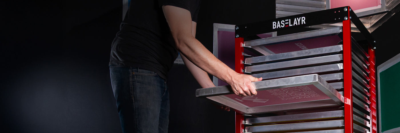 Person using a BASLAYR frame rack in a dark background