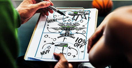 Coach sketches a “Machine Madness” play on a clipboard with a Riley Flash Quartz dryer, Riley Hopkins 360 press, and a Riley Cure conveyor dryer, plus “10% OFF,” basketball in the background.